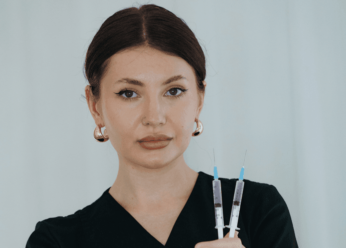 Med spa professional holding cosmetic treatment syringes