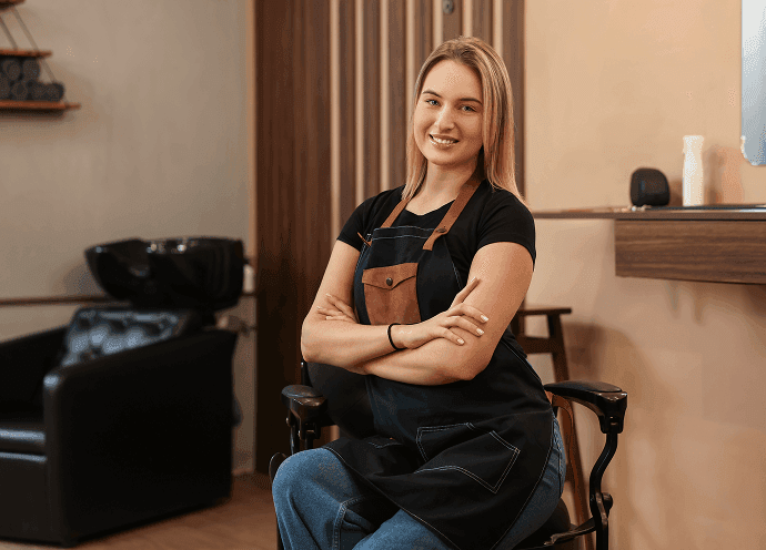 Independent hair stylist seated in her private salon suite at The Hive