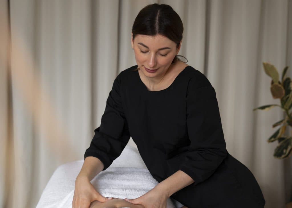Massage therapist treating a client in a private spa suite